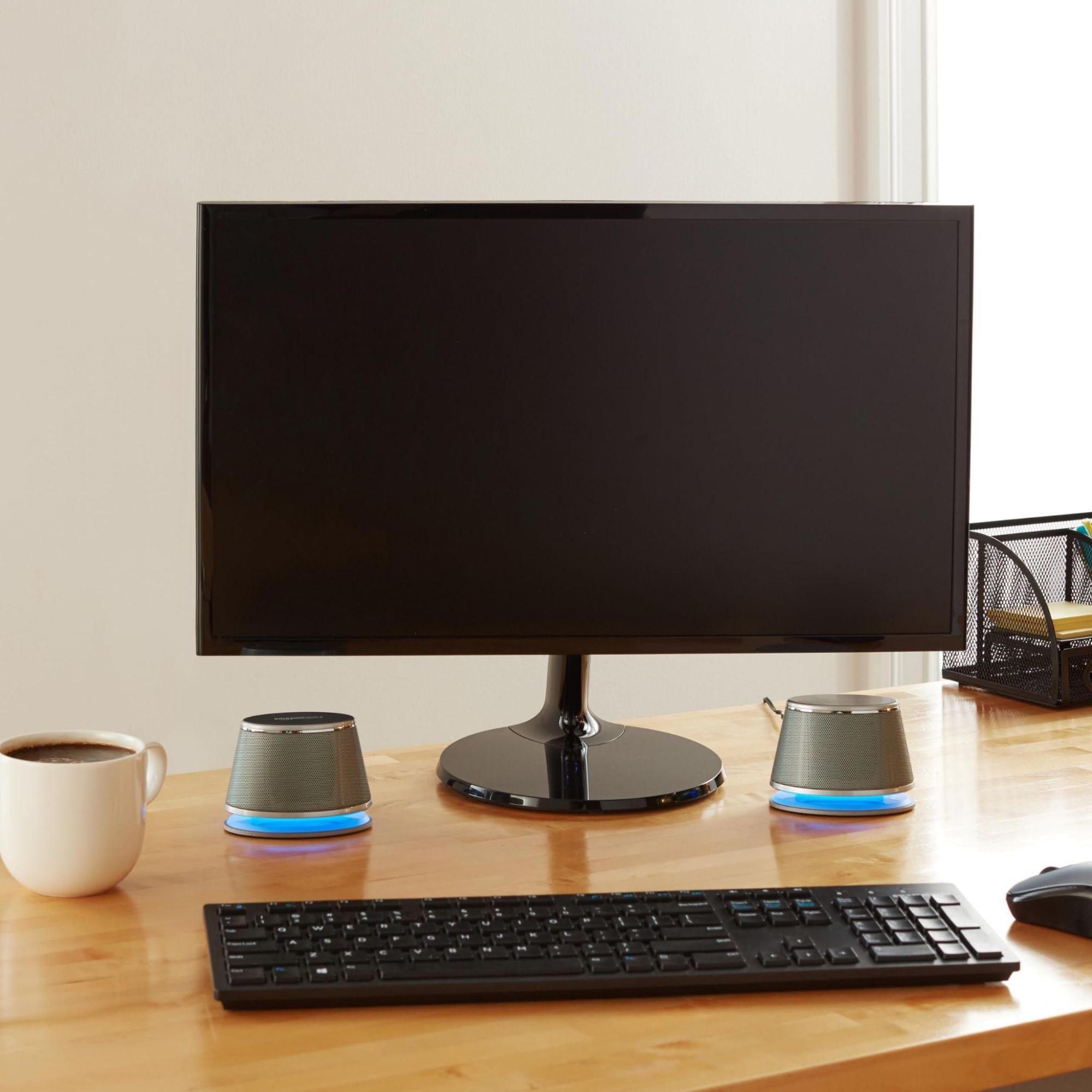 Amazon Basics Stereo 2.0 Speakers placed with monitor on a wooden table 