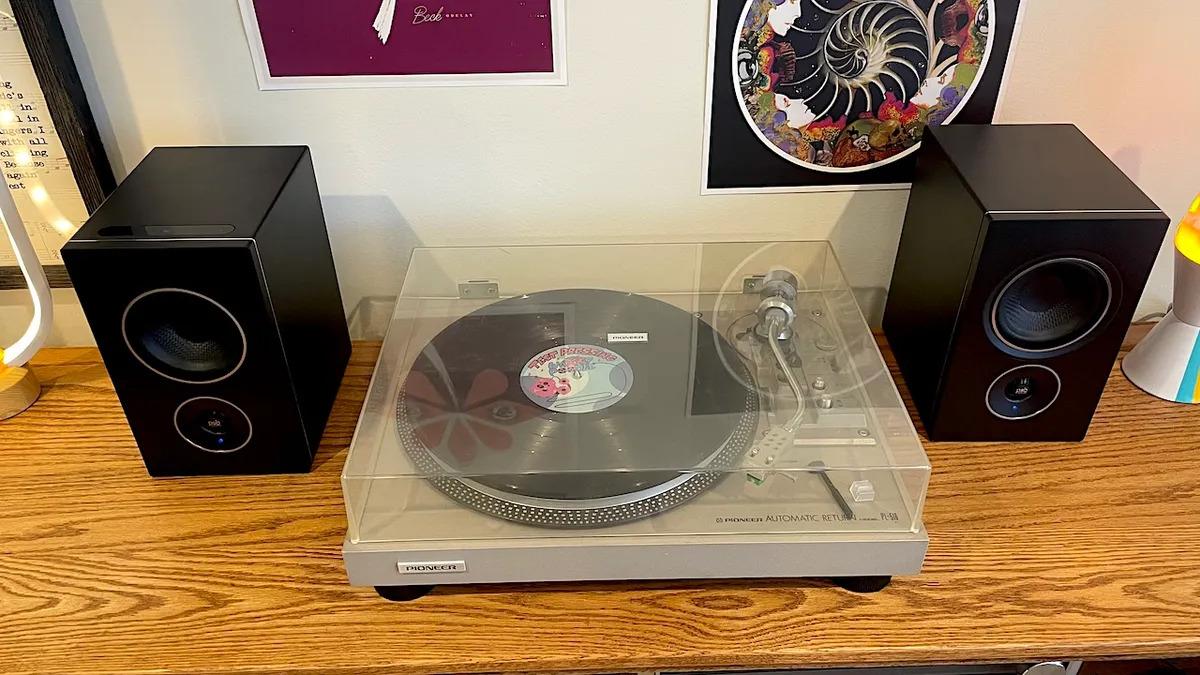 vinyl setup, 2 record player speakers on a wooden table